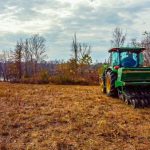Tractor clearing brush